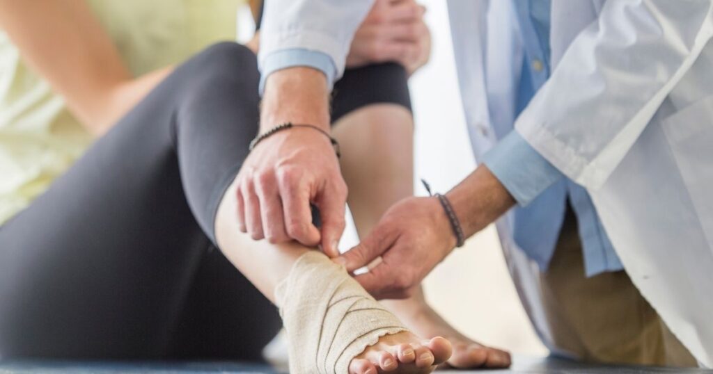 A physician treating an ankle injury.