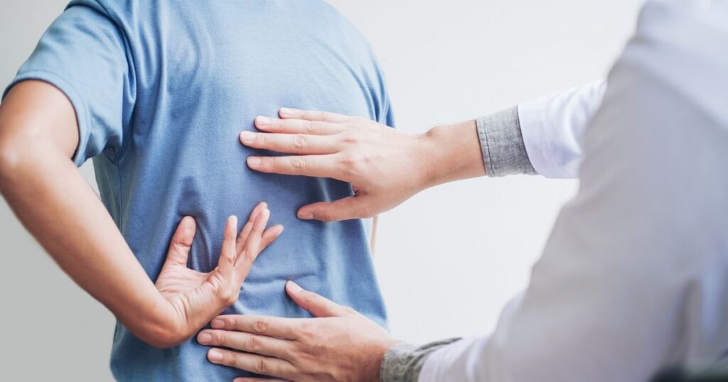 Physician examining person's back.