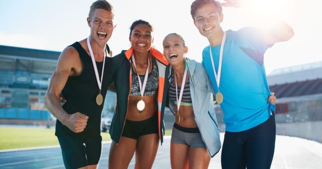 Smiling athletes wearing medals.