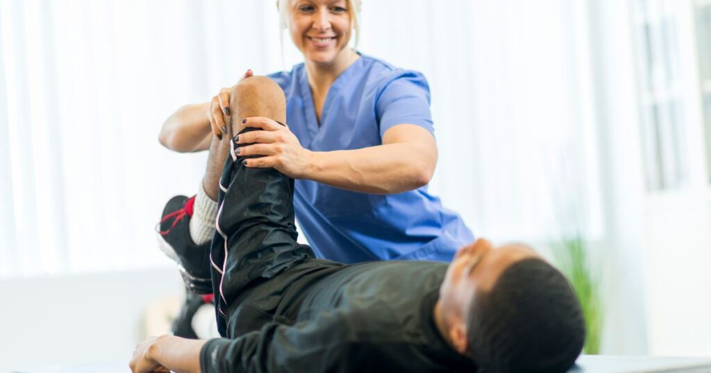 A physical therapist working with a male patient.